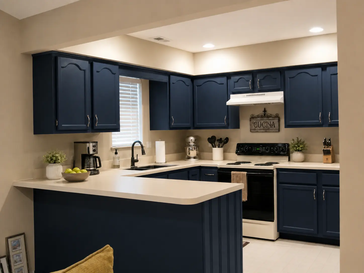 The same peninsula kitchen with cabinets resprayed in deep navy